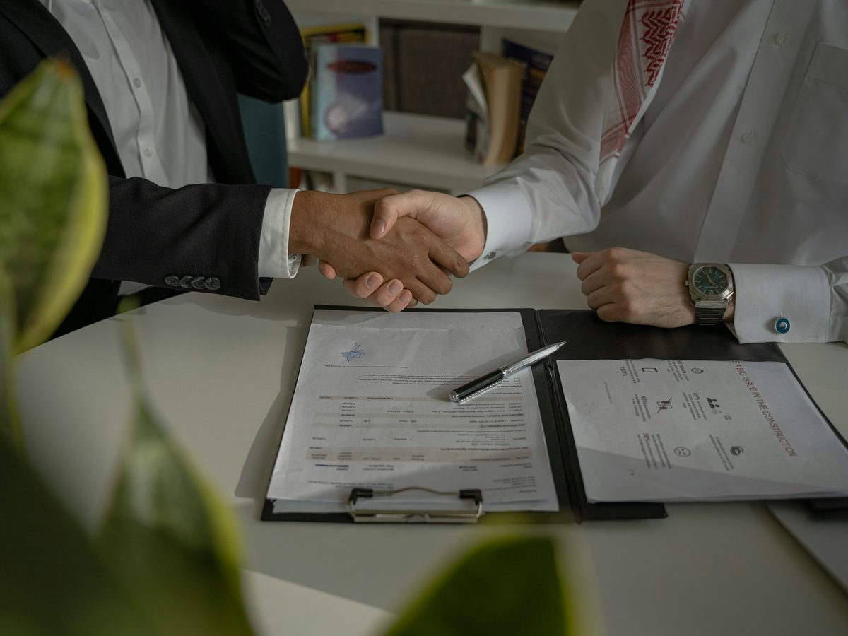 Aperto de mão sobre um contrato assinado