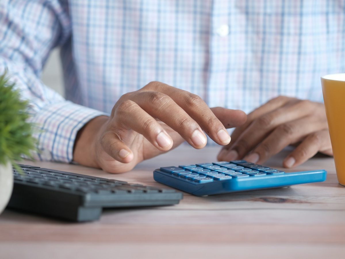 Calculadora, documentos e café sobre a mesa de trabalho